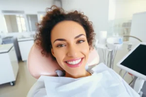 A smiling woman at a dental clinic showcasing her bright smile, representing the benefits of a Rubicare Individual Subscription.