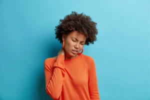 Young woman experiencing neck pain, considering if insurance cover chiropractic visits, and exploring options with Rubicare’s Health Savings Plan.