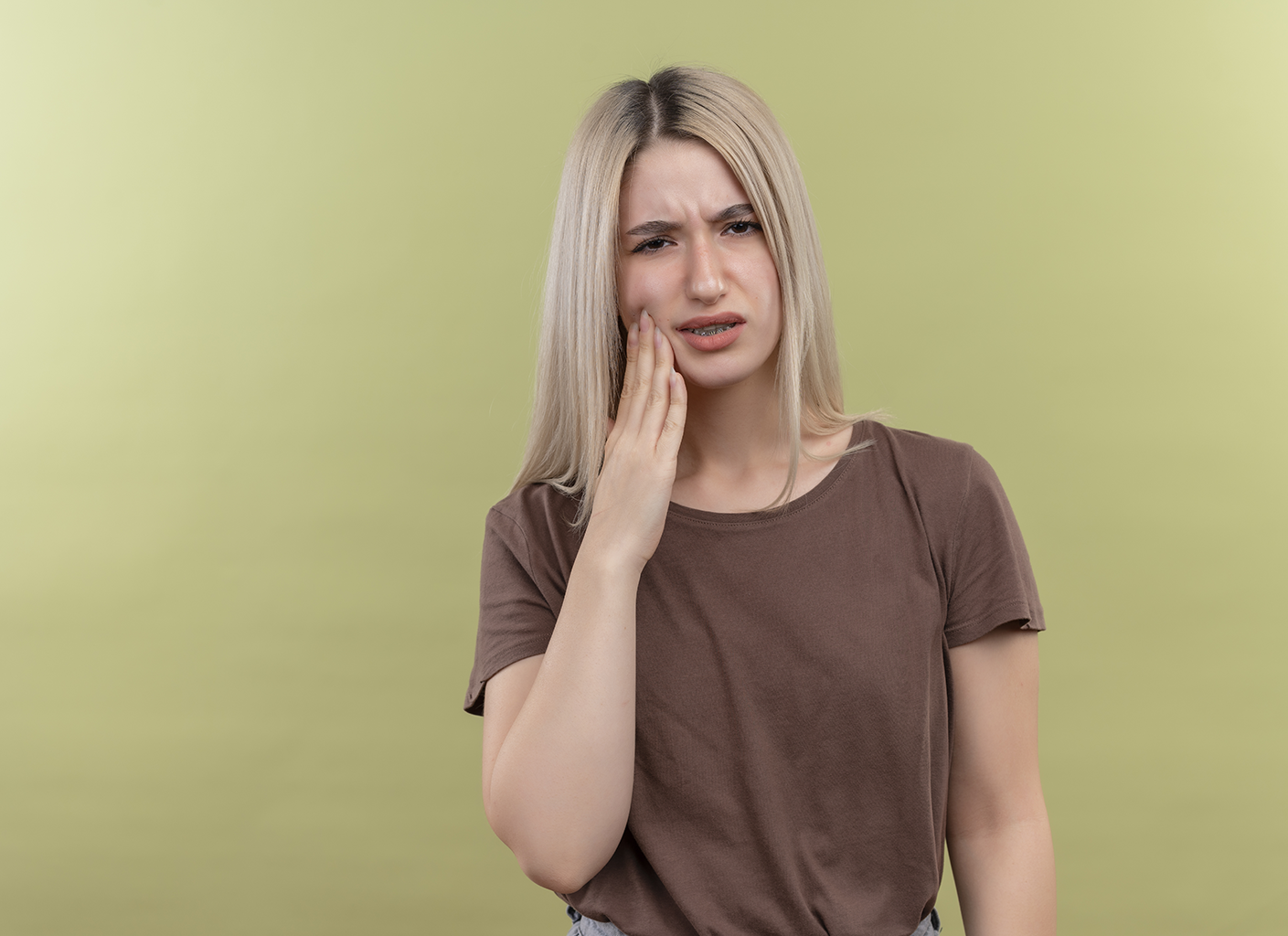 Young woman experiencing a dental emergency with tooth pain, showcasing the importance of dental savings through Rubicare Health Savings Plan.